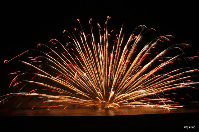 三重 熊野大花火大会　全速力で走る船から点火された花火玉を次々に海に投げ入れ開花させる「海上自爆」